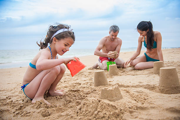 istock young couple is playing at the beach with their daughter 475583162