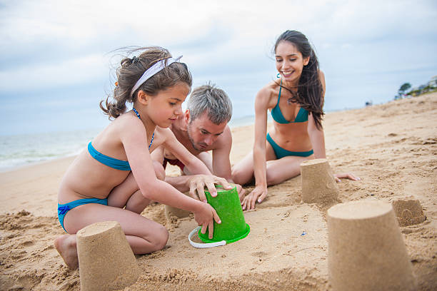 istock young couple is playing at the beach with their daughter 475583164