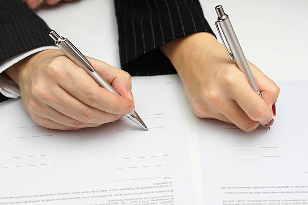 istock man and woman signing document or prenup 475584895