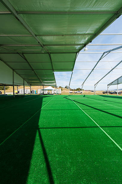 istock Huge white tent with green floor in field 475585574