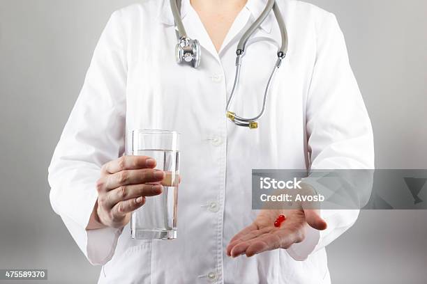 Female Doctors Hand Holding Glass Of Water Giving Pills Close Stock Photo - Download Image Now