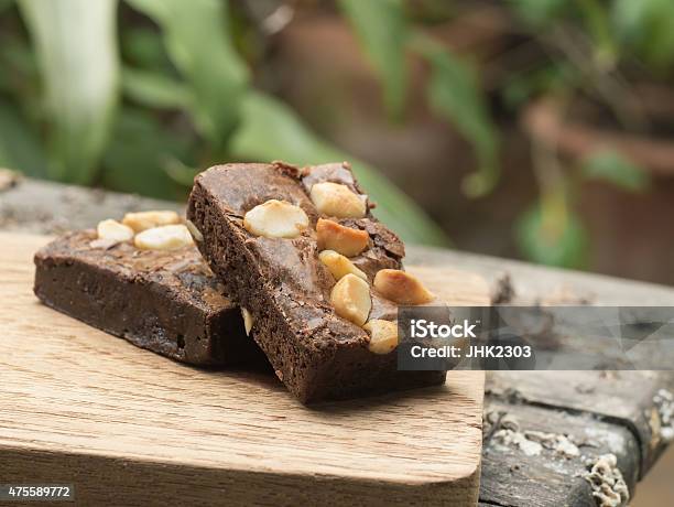 Cake Chocolate Brownie On A Wooden Plate Stock Photo - Download Image Now - Brownie, Macadamia Nut, 2015