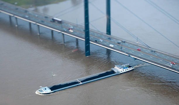 river Rhine and Düsseldorf, seen from the television tower Rheinturm. Barge heavily loaded with coal is passing the bridge Rheinkniebrücke.