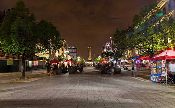 Buildings in Old Town Montreal Montreal, Canada - May 17, 2015: A view up Place Jacques Cartier in Montreal at night. The blur of people and Nelsons Column can be seen. place jacques cartier stock pictures, royalty-free photos & images