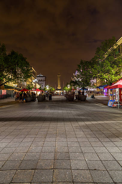 Old Montreal at Night Montreal, Canada - May 17, 2015: A view up Place Jacques Cartier in Montreal at night. The blur of people and Nelsons Column can be seen. place jacques cartier stock pictures, royalty-free photos & images