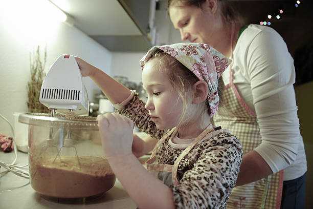 istock Mother and daughter preparing dough in the kitchen 475602588