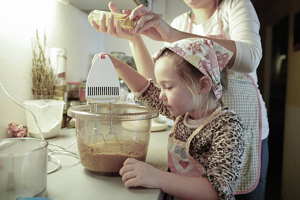 istock Mother and daughter preparing dough in the kitchen 475602592
