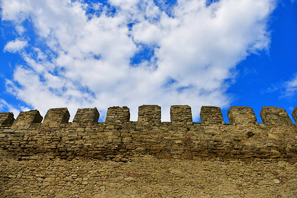 Detail of the wall of the venetian (Koules) fortress at the seaside. Golden color of the stones during the late afternoon sunlight, bright blue sky. Heraklion, Crete, Greece.