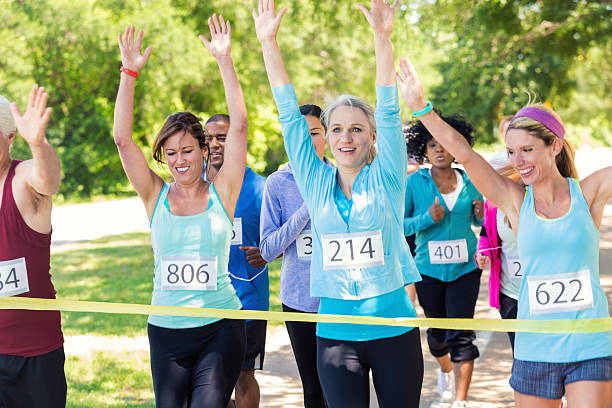 istock Runners celebrating as they cross finish line together during race 475610026