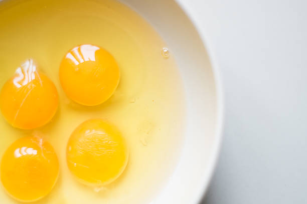 istock Four yellow egg yolks in a white bowl. 475612015