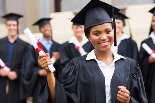 pretty african american female graduate holding her diploma at ceremony