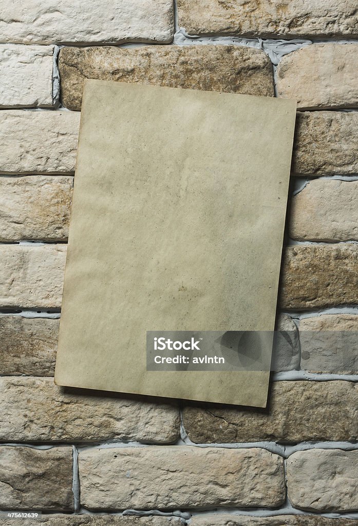 paper on wall old paper on brick wall Backgrounds Stock Photo