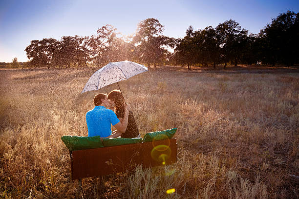 couple with umbrella under rain stock photo