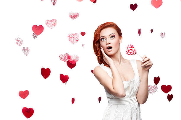 istock surprised red-haired woman holding lollipop 475614497