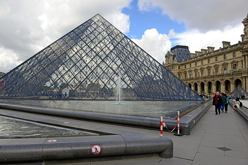 Paris, France - May 20, 2015: Marked by its signature glass Pyramids, The Louvre is one of the largest and most visited museums in the world and is one of the major tourist’s attraction for France.