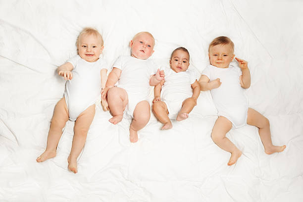 istock Four babies lay in a row on the white background 475618532