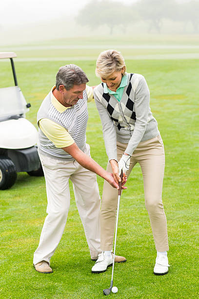 istock Golfing couple putting ball together 475621292