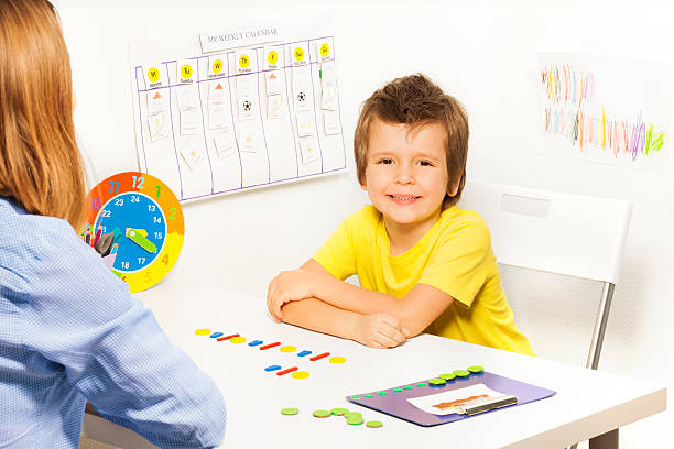 istock Smiling boy with colorful coins in order 475621384