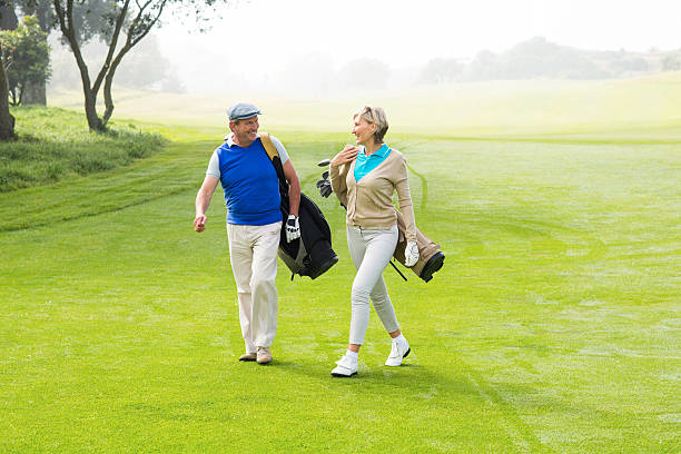 istock Golfing couple walking on the putting green 475623516