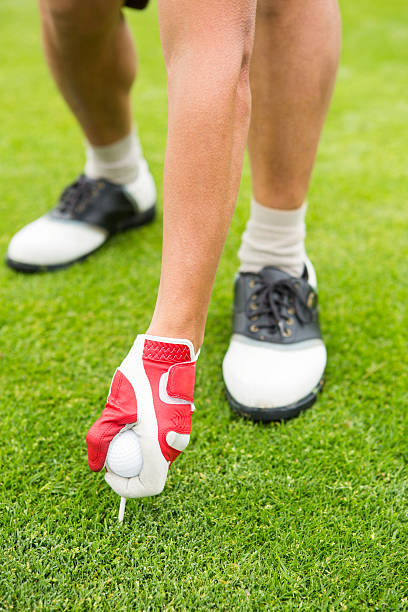 istock Golfer placing golf ball on tee 475624024