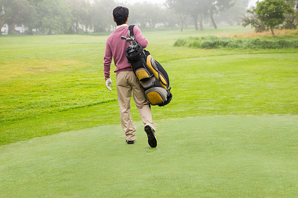 istock Golfer walking away holding golf bag 475624030