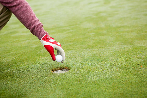 istock Golfer trying to flick ball into hole 475624056