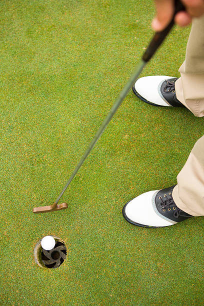 istock Golfer putting golf ball in the hole 475624102
