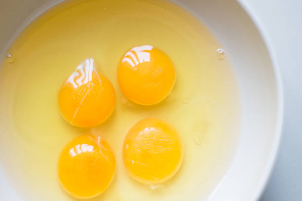 istock Four yellow egg yolks in a white bowl. 475626035