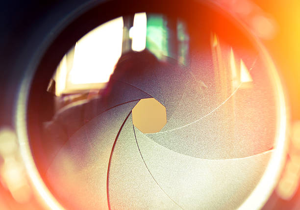 The diaphragm of a camera lens. The diaphragm of a camera lens aperture. Selective focus with shallow depth of field. Color toned image. aperture stock pictures, royalty-free photos & images