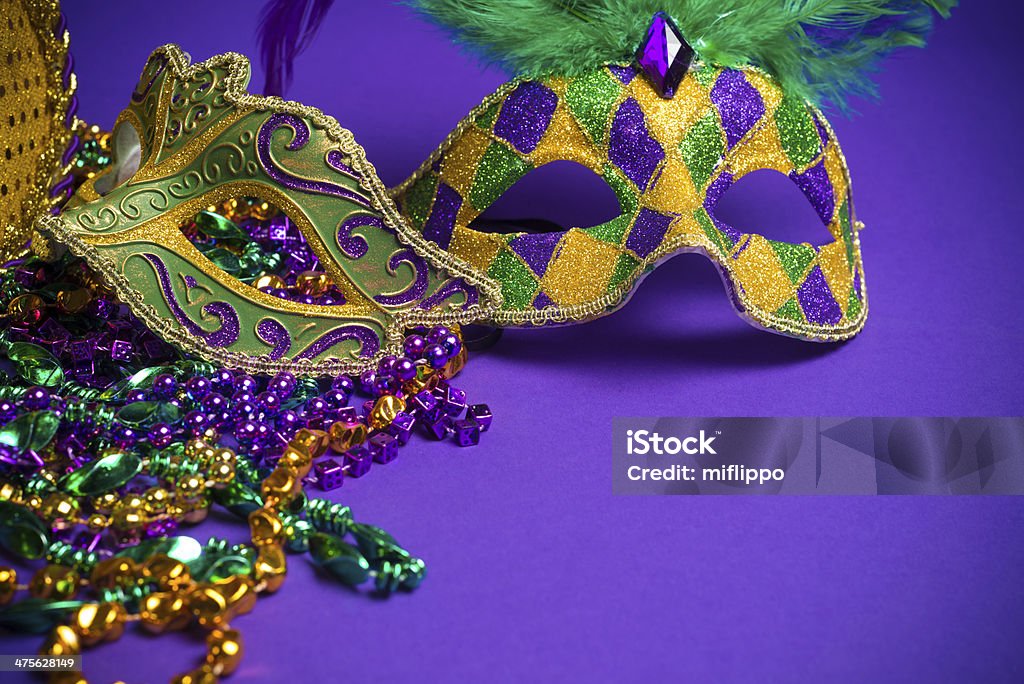 Assorted Mardi Gras or Carnivale masks on a purple background Festive Grouping of mardi gras, venetian or carnivale masks on a purple background Mask - Disguise Stock Photo