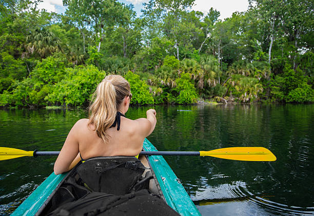 istock Woman Kayaking down a beautiful tropical jungle river 475630018