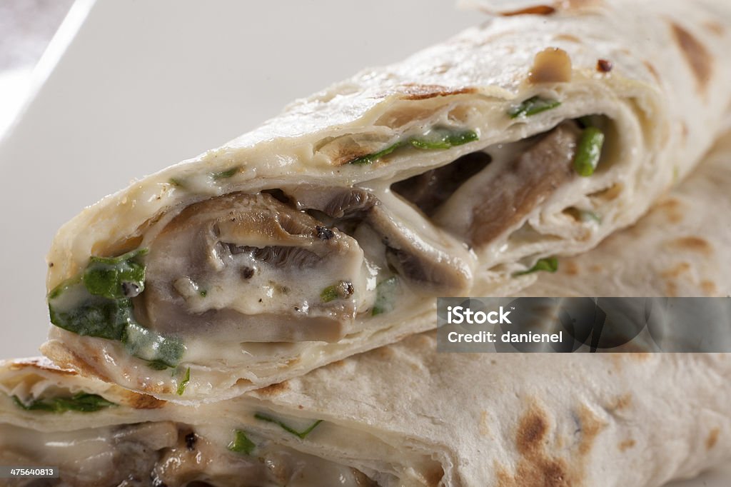 Burritto Savoury pancake with creamy mushroom and spinach filling. Edible Mushroom Stock Photo