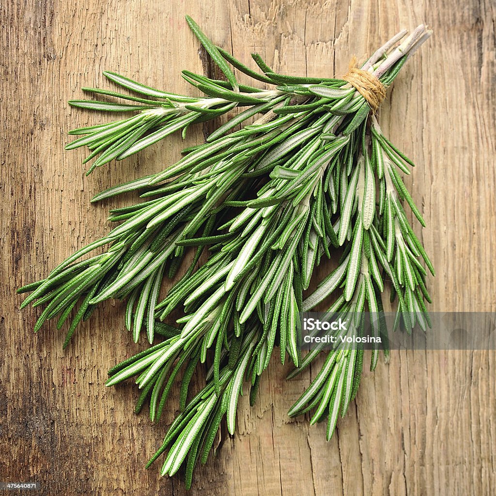 Twigs of rosemary Twigs of rosemary on wooden texture Branch - Plant Part Stock Photo