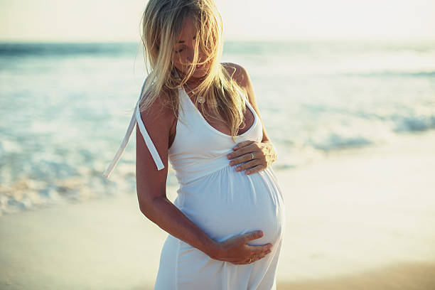 mulher grávida na praia - dress human pregnancy young women women imagens e fotografias de stock