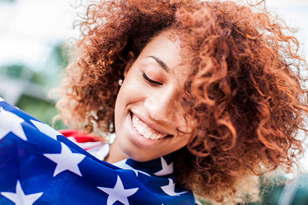 istock Beautiful afro woman holding US flag 475642684