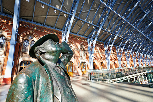 London, England - June 8, 2014. Standing in the restored and redeveloped St Pancras International rail station is a statue of Sir John Betjeman who saved the building from demolition