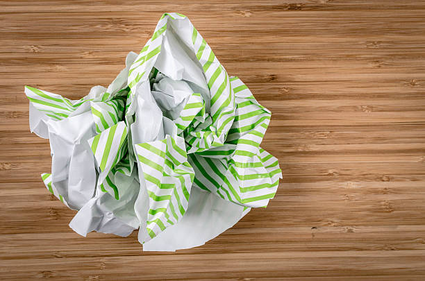 pognieciony striped pakowanie na prezent papieru na drewnianym stole - paper crumpled wastepaper basket garbage zdjęcia i obrazy z banku zdjęć