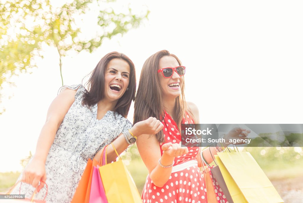 two smiling teenage girls with shopping bags shopping, sale and gifts concept - two smiling teenage girls with shopping bagsshopping, sale and gifts concept - two smiling teenage girls with shopping bags 2015 Stock Photo