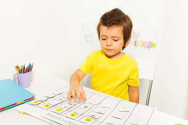 Photo of Boy plays in developing game pointing at calendar