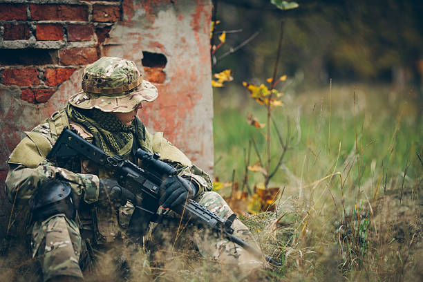 istock soldier with rifle in the forest 475664018