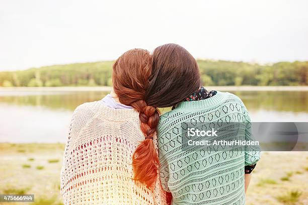 Two Sisters With Interwoven Hairs Stock Photo - Download Image Now - 2015, Adult, Adults Only