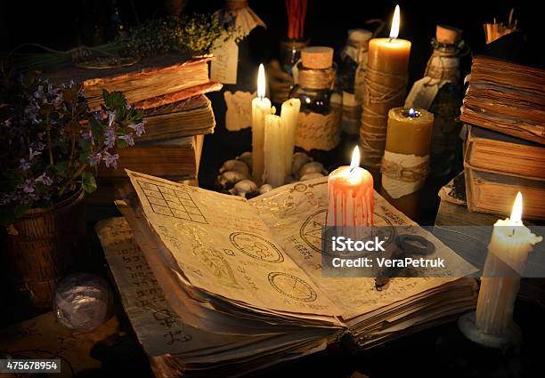 Bloody Candle With Rustic Key On Witch Book In Candle Light Stock Photo - Download Image Now
