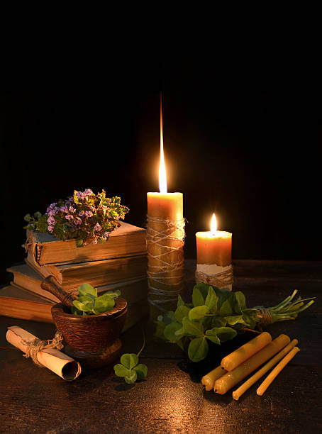 istock Still life with candles, clover and books on black 475687876