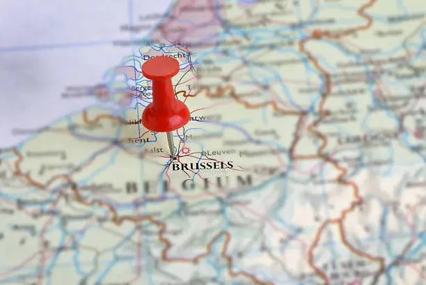 A red push-pin marking Brussels on a map of Belgium