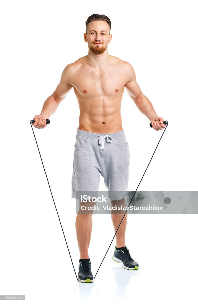 Athletic attractive man jumping on a rope on the white Athletic attractive man jumping on a rope on the white background 20-29 Years Stock Photo