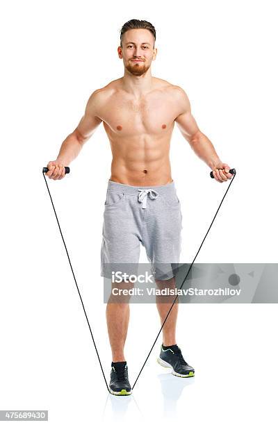 Athletic Attractive Man Jumping On A Rope On The White Stock Photo - Download Image Now