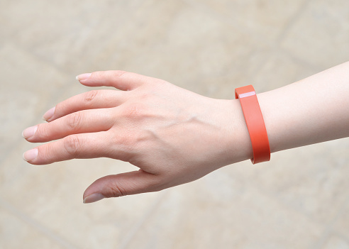 Vancouver, BC, Canada -- May 30, 2015:Close up of a woman wearing a Fitbit Flex on her wrist. A Fitbit in a wireless activity and sleep monitor wristband that promotes activity and wellness.