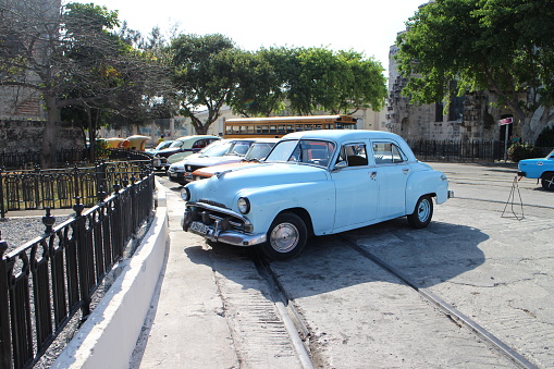 Havana, Сuba - April 7, 2015: Classic American cars parked in old town Havana in Cuba. Oldsmobile cars are often used as a tourist taxis in Cuba.