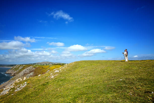 excursionismo pareja mirando el mapa de gower headland - map uk hiking reading fotografías e imágenes de stock