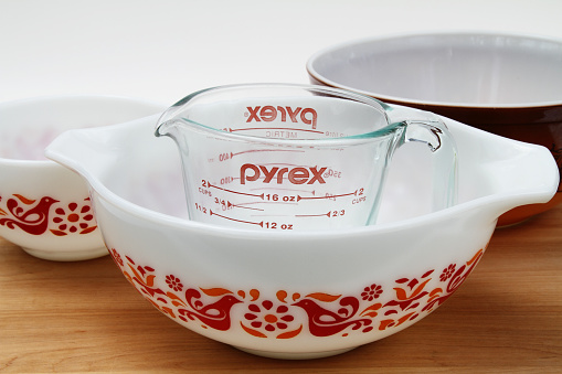 West Palm Beach, USA - May 30, 2015: A PYREX clear glass measuring cup with several vintage Pyrex mixing bowls. The white bowls feature the friendship design. Pyrex recently celebrated its 100th anniversary since it was introduced by Corning in 1915. The brand is now produced by World Kitchen LLC, a Corning spinoff. 